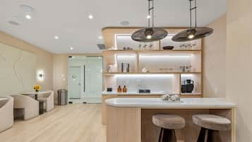 Eine moderne Küche mit Bar, Holzschränken und Pendelleuchten.