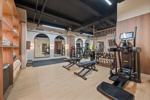 A gym with exercise equipment, wooden walls, and mirrors.