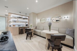 A modern interior with a kitchen island, round tables, and a sofa.