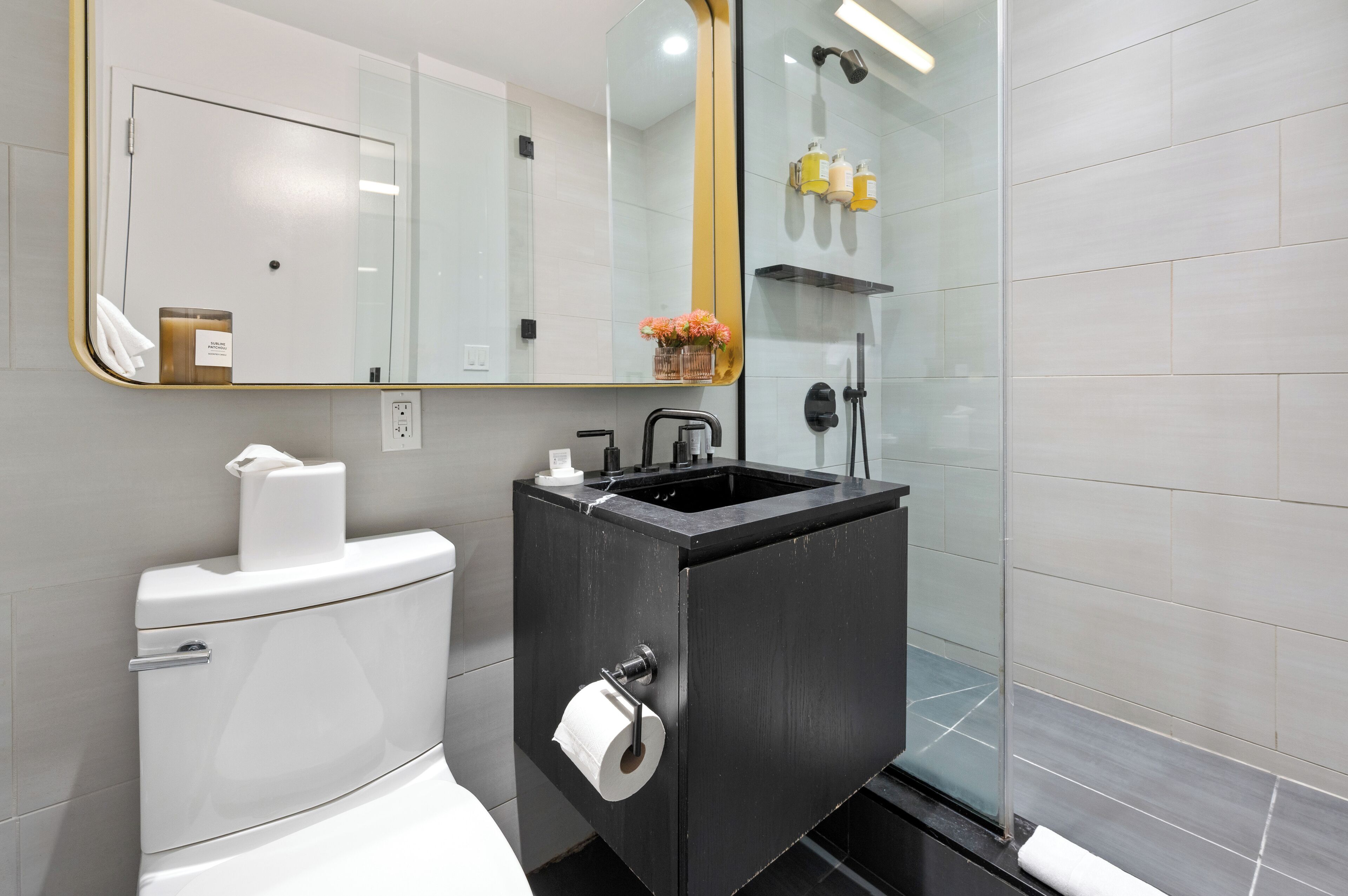 Ein modernes Badezimmer mit Toilette, Waschbecken und Dusche.