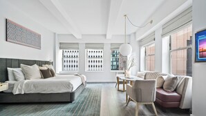A modern bedroom with a large bed, a desk, and a sofa. - 17John  (New York)