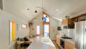A modern kitchen with a central island, wooden cabinets, and a stainless steel refrigerator. - Walkable Modern Retreat (Portland)