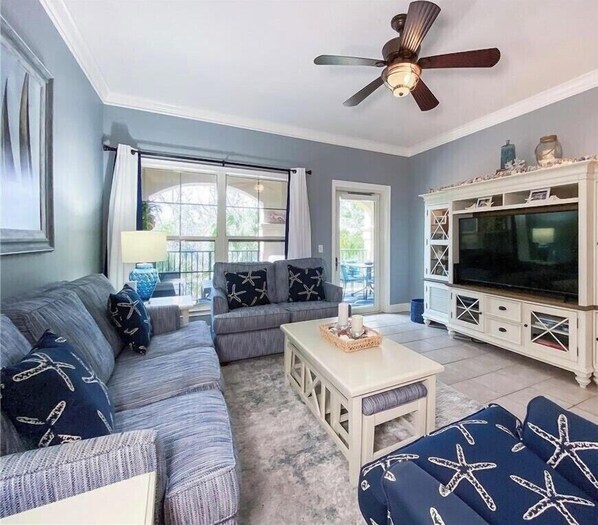 A living room with a sectional sofa, a coffee table, and a TV stand.