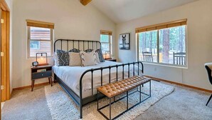 A bedroom with a bed, bedside tables, a bench, and large windows. - Lincoln Log Cabin, Tranquility close to Downtown (Flagstaff)
