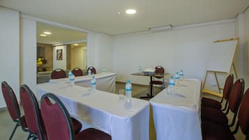 A conference room with tables, chairs, and a whiteboard.