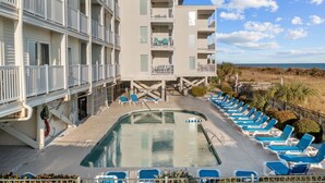 A hotel with a pool, multiple balconies, and a view of the beach. - 2/2 Oceanfront Condo w/ Pool - Windy Hill (North Myrtle Beach)