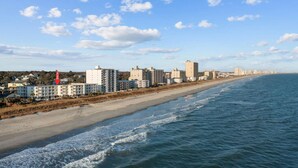 A coastal hotel with multiple buildings along the beachfront, a sandy beach, and the ocean. - 2/2 Oceanfront Condo w/ Pool - Windy Hill (North Myrtle Beach)