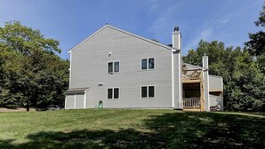Ein zweistöckiges Haus mit Veranda und Garage.