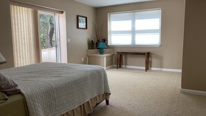 Une chambre à coucher avec un lit, une fenêtre, une table de chevet et une chaise.