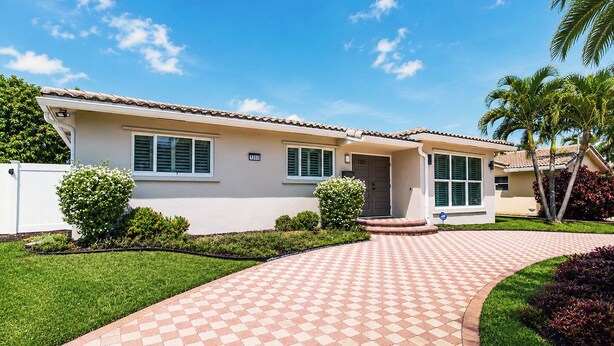 A two-story house with a tiled walkway leading to the front door, surrounded by well-maintained lawns and small bushes. - Premium Luxury  5BR/4BA Villa near Hollywood Beach (Hollywood)