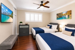 A hotel room with two beds, a ceiling fan, a window with blinds, a TV on the wall, and a bench. - Premium Luxury  5BR/4BA Villa near Hollywood Beach (Hollywood)