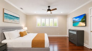 A bedroom with a bed, a ceiling fan, a window with blinds, a TV, and a dresser. - Premium Luxury  5BR/4BA Villa near Hollywood Beach (Hollywood)
