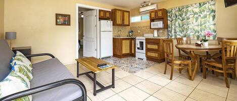 A compact living space with a kitchenette, a dining area, and a small seating area.
