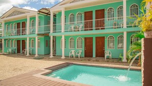 A two-story building with a swimming pool in front. - Cococabana4 newly renovated 1BR/1BA apar in downtown Coco, 5 min walk to beach. (Playas del Coco)
