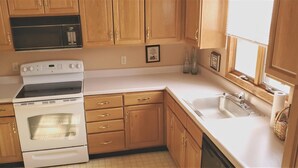 A kitchen with wooden cabinets, a built-in oven, a microwave, and a sink. - On the Island!  Three bedroom, two bath home. (Holiday Island)