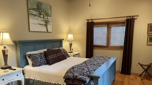 A bedroom with a bed, nightstands, a window with curtains, a painting on the wall, and a wooden floor. - Casa Cortina: Eclectic Highlands Retreat w/ Covered Deck | 4 Min to Main Street (Highlands)