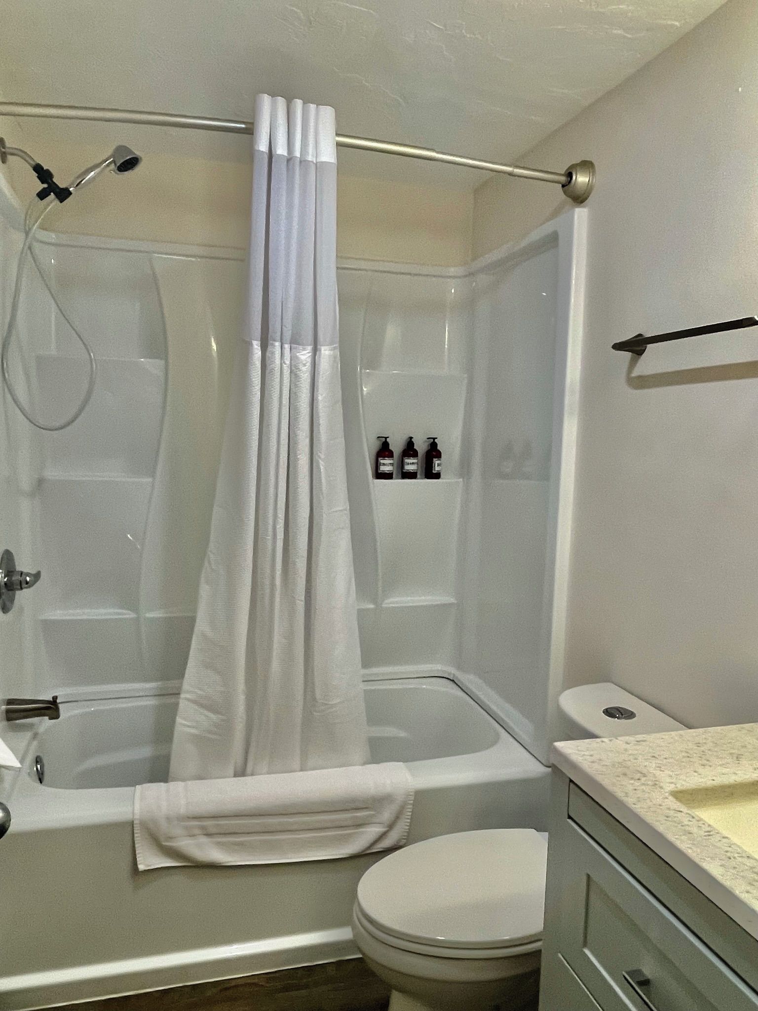 Een badkamer met een bad, douche, toilet en een handdoekrek.