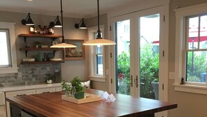 Een moderne keuken met een groot eiland, hanglampen en uitzicht op de omgeving.