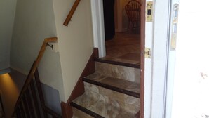 A staircase with wooden handrails and a door leading to another room. - 3blk St Mary 11to Mayo Pet Friendly CoveredByFaith (Rochester)