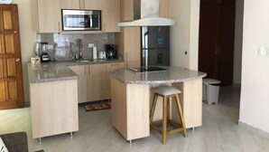 Eine moderne Küche mit einer zentralen Kochinsel, Edelstahlgeräten und Holzschränken.
