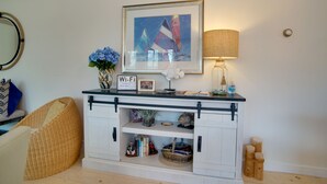 Een woonkamer met een open haard, een lijstwerk schilderij, een Wi-Fi signaal en een lamp.