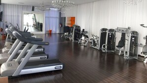 A gym with treadmills, weight machines, and a large mirror. - Icon Vallarta Apartments (Puerto Vallarta)