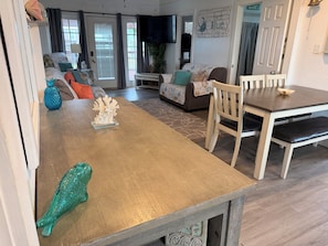A dining area with a wooden table, chairs, and a decorative coral piece. - Charming recently updated beach house with ocean views  (Freeport)