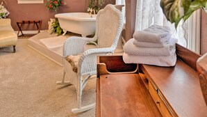 A bathroom with a bathtub, a white wicker chair, a wooden bench, and a potted plant. - Pet-Friendly Apt: 2 Blocks to Riverside Park! (Yankton)