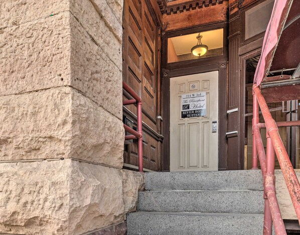 A hotel entrance with a stone facade, a wooden door, and a sign indicating '214 W 3rd The Riverfront Hotel River Rose Suites'. - Pet-Friendly Apt: Walk to Missouri River! (Yankton)