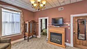 A living room with a fireplace, television, and a wooden cabinet.
