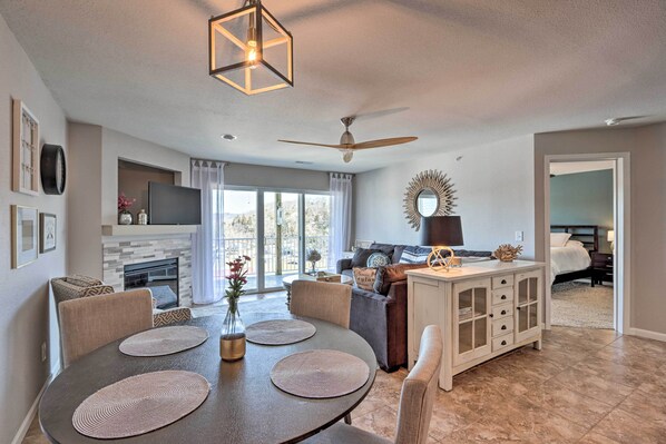 A modern living room with a dining area, fireplace, and large windows. - 'Serenity at the Lake' in Ozarks w/ View (Camdenton)