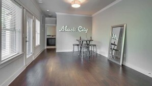 Ett rymligt rum med en matplats, en spegel och en väggskylt med texten ”Music City”.