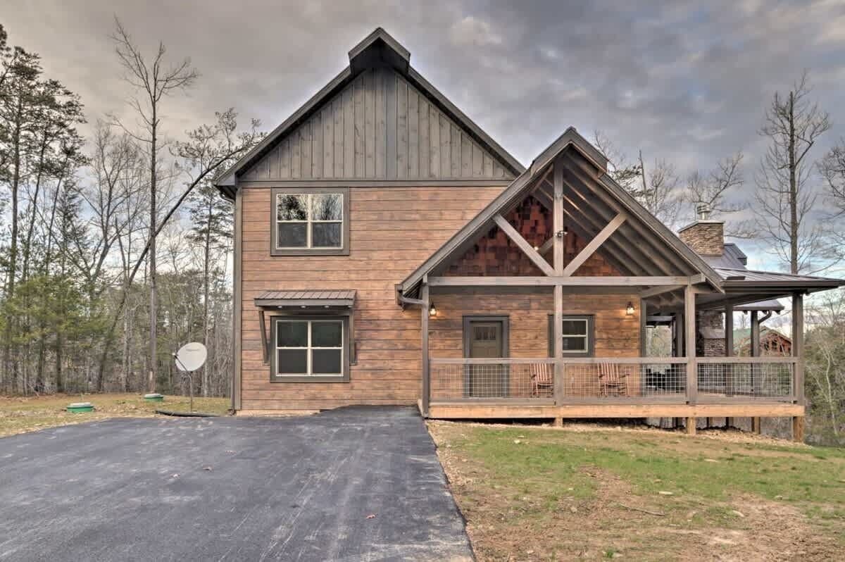 A two-story wooden house with a large porch and a covered outdoor area.
