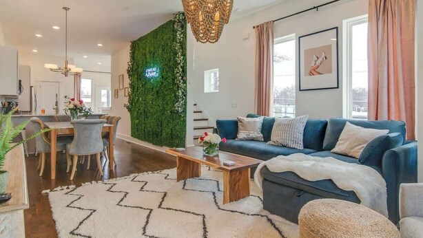 Un salon moderne avec un canapé bleu, une table basse en bois et un mur vert.