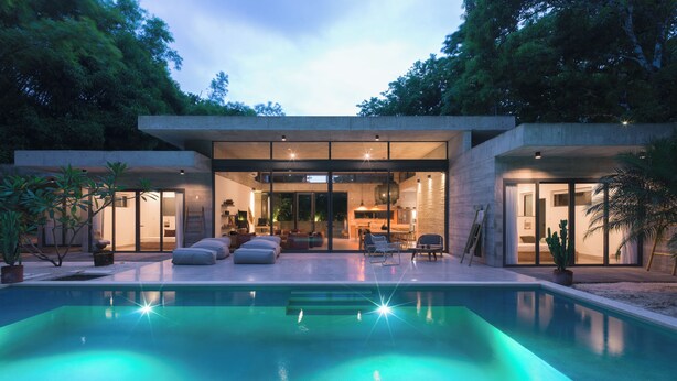 A modern house with a swimming pool, outdoor seating, and a well-lit interior. - Casa Taman, Beachside villa by Elite Beach Villas (Cobano)