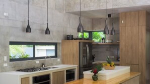 A modern kitchen with a central island, stainless steel appliances, and pendant lighting. - Casa Taman, Beachside villa by Elite Beach Villas (Cobano)