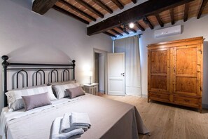 Een slaapkamer met een bed, nachtkastjes, een kledingkast en een deur.