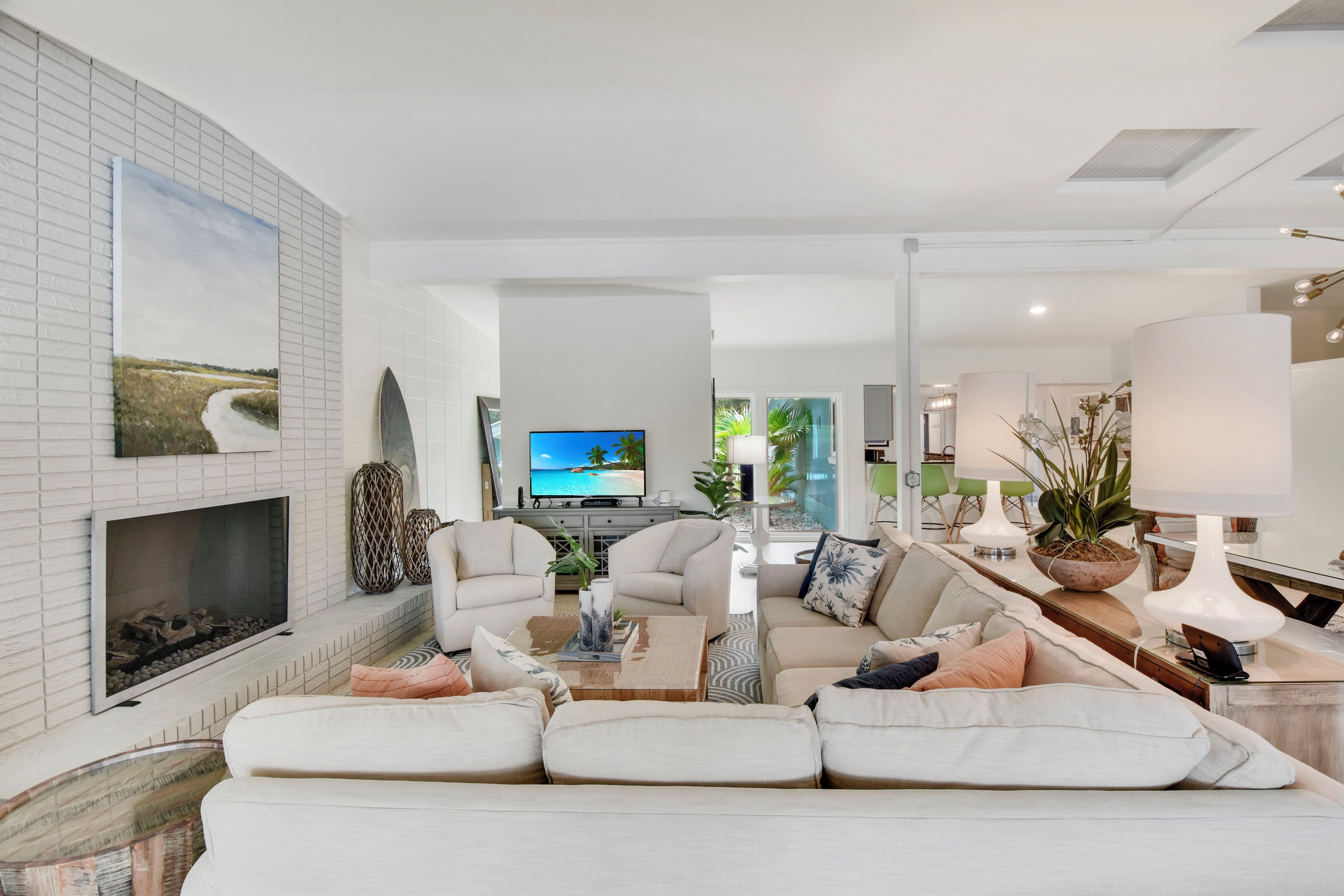 A modern living room with a fireplace, a television, and a dining area with a table and chairs.