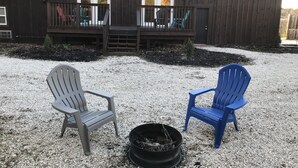 A wooden cabin with a deck, two Adirondack chairs, and a fire pit. - Hikers Retreat• Handcrafted Cabin in RRG • PET FRIENDLY• Location is Key  (Pine Ridge)