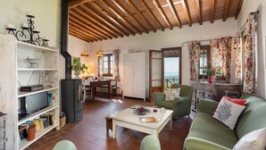 Una sala de estar acogedora con chimenea, comedor y vistas al mar.