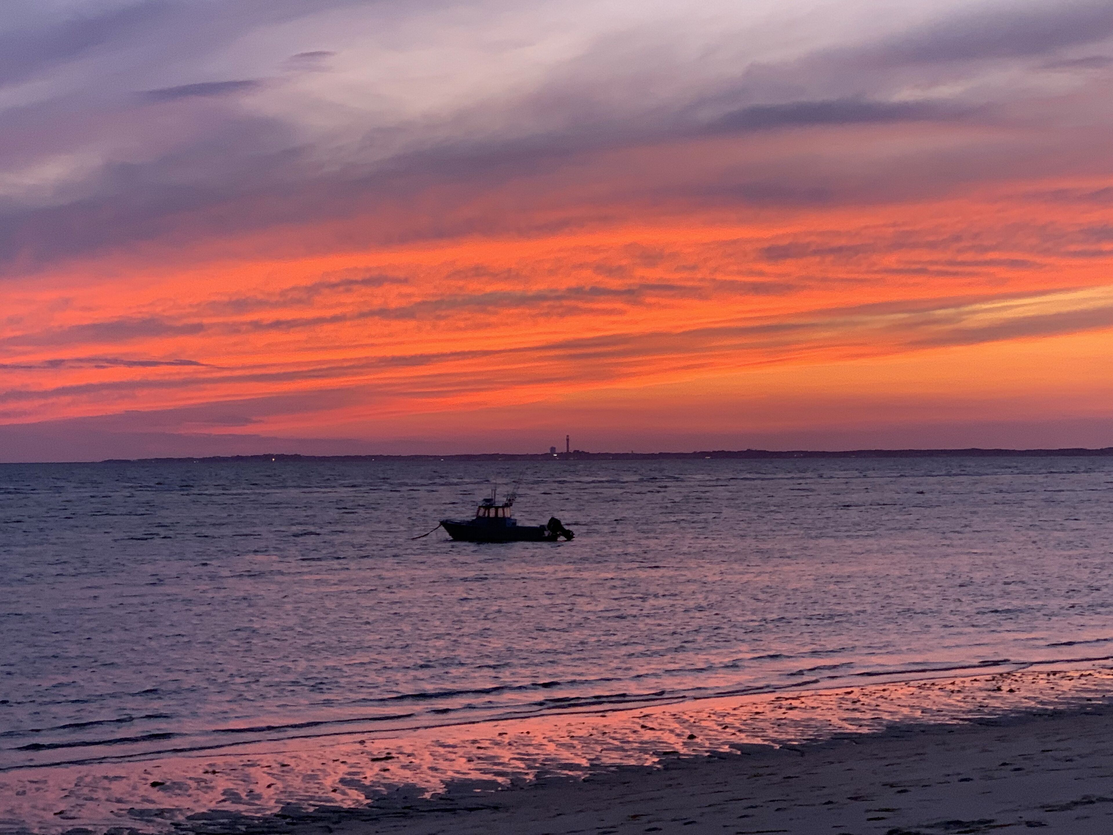 A boat on calm waters during sunset.
