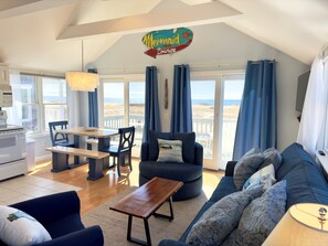 En hyggelig stue med havudsigt, et spiseområde og et tekøkken.