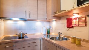 A modern kitchen with wooden cabinets, a stainless steel sink, and a built-in stove.