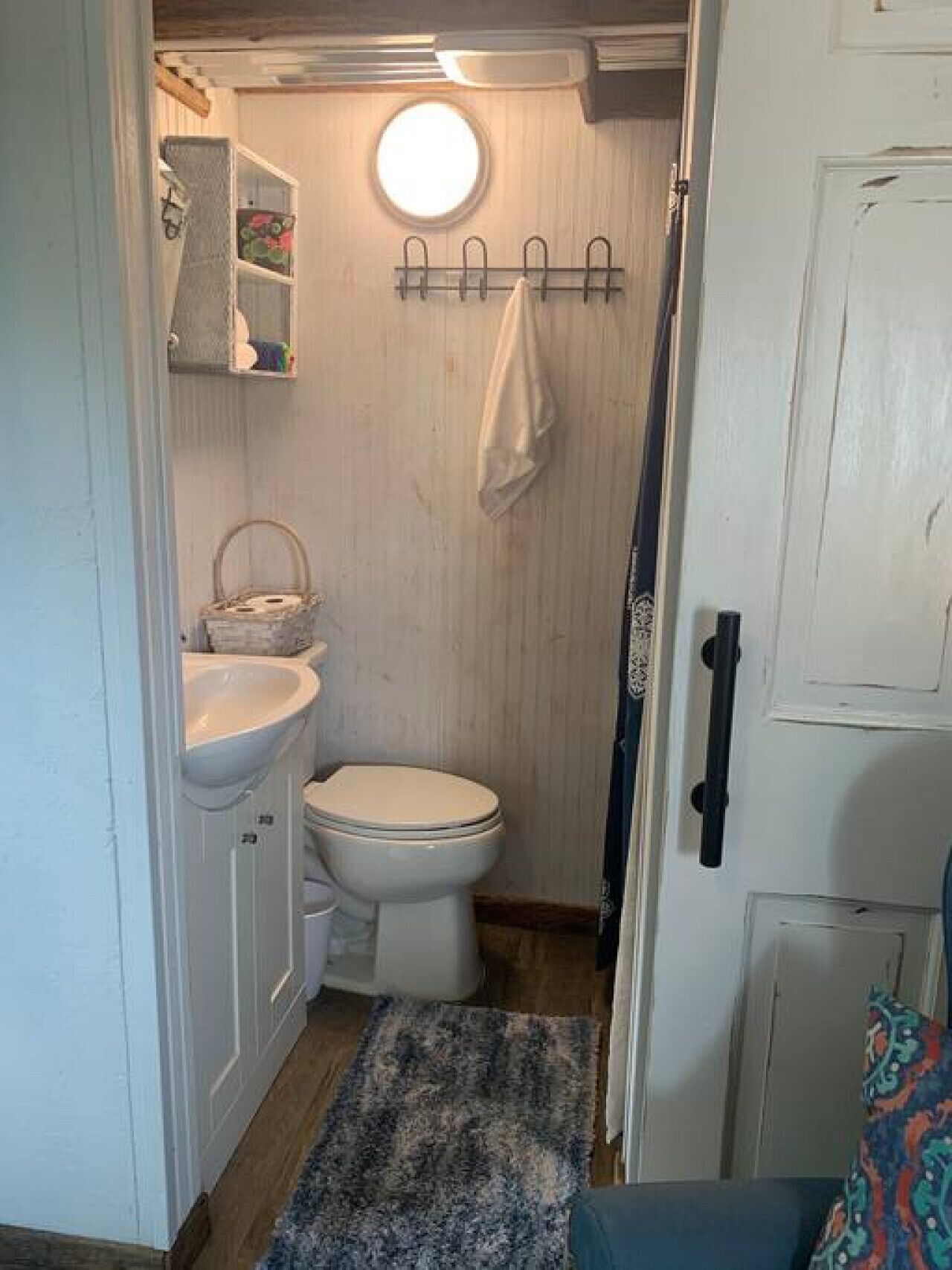 Une petite salle de bain comprenant des toilettes, un lavabo et une petite fenêtre.