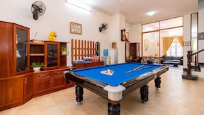 A pool table in a room with wooden cabinets, a fan, and a chandelier. - ViVa Villa Vung Tau - Phan Chu Trinh (Ho Chi Minh City)
