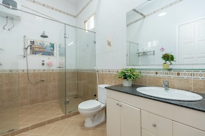 A modern bathroom with a glass-enclosed shower, a toilet, and a sink with a mirror above it. - ViVa Villa Vung Tau - Phan Chu Trinh (Ho Chi Minh City)