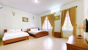 A hotel room with two wooden beds, a wooden dresser, a television, and a window with curtains. - ViVa Villa Vung Tau - Phan Chu Trinh (Ho Chi Minh City)
