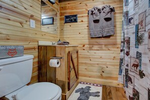 A wooden bathroom with a toilet, a sink, a towel rack, and a sign indicating soap and water are free. - Cabin in RRG• Pet Friendly • Hi Speed 🛜 Hikers Welcome (Pine Ridge)