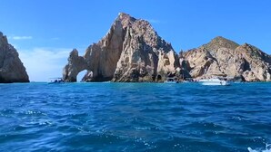 Un paysage côtier avec des falaises rocheuses et une eau d’un bleu limpide.