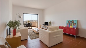A modern living room with a sofa, a coffee table, a TV stand, and a red cabinet. - Apartment "Meia Praia Beach" with Sea View, Pool, Wi-Fi, Balcony & Garden (Lagos)